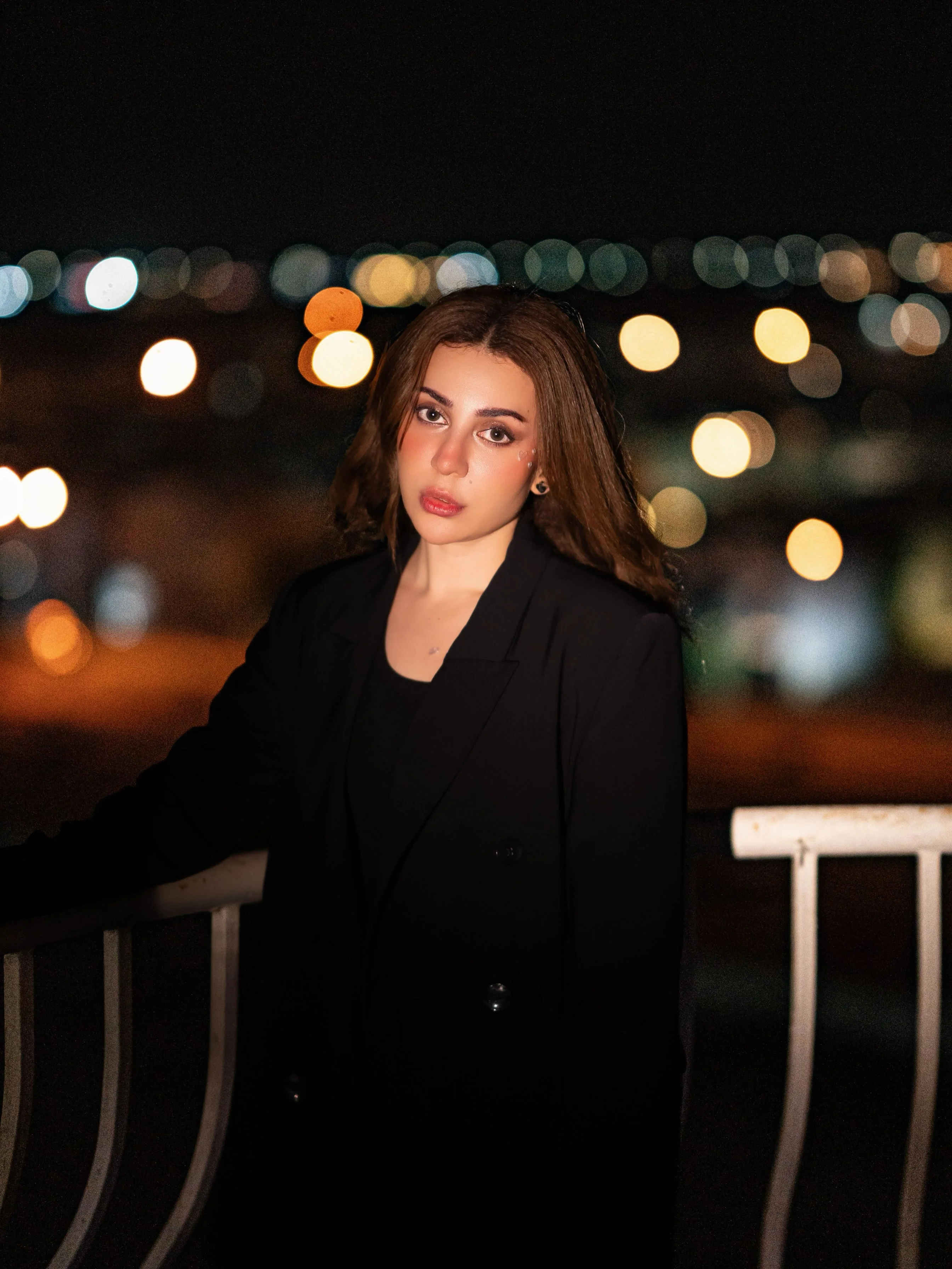 Pakistani actress Neha Khan in a black blazer, photographed against city lights